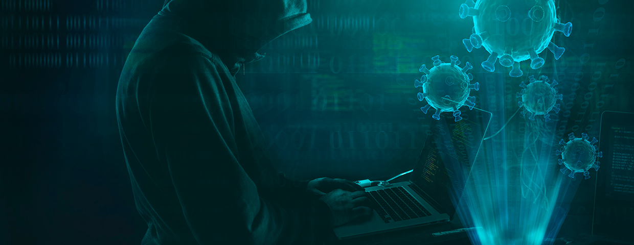 person in a dark hoodie typing on a notebook, controlling virus