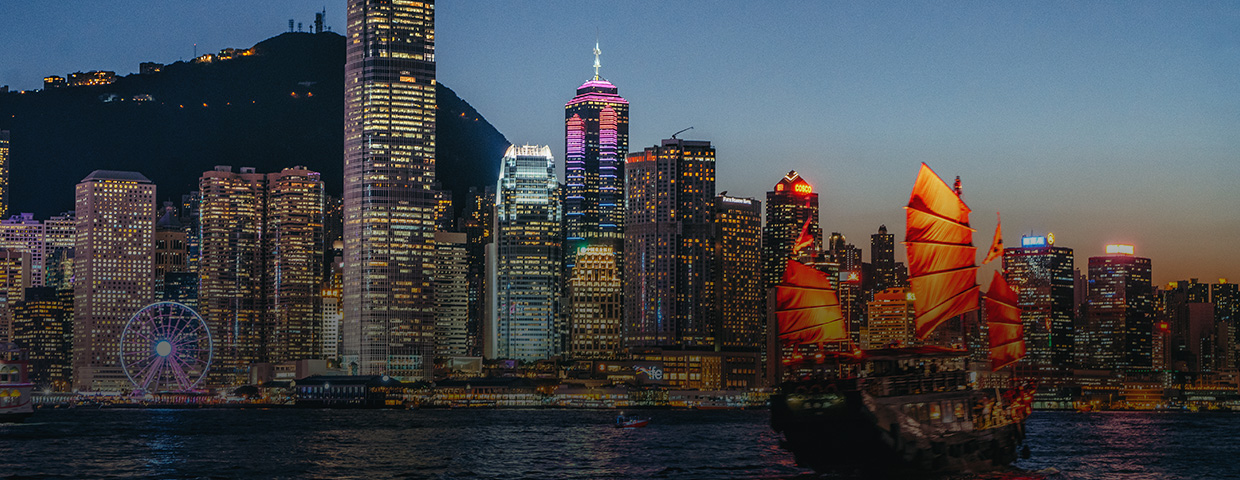 Victoria Harbour at night with brightly illuminated skyscrapers in the background