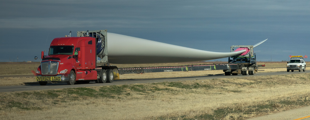 Trucks transport a giant wind blade in the Texan desert