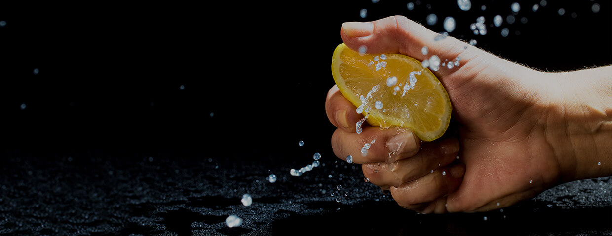 lemon squeezed in hand on black background