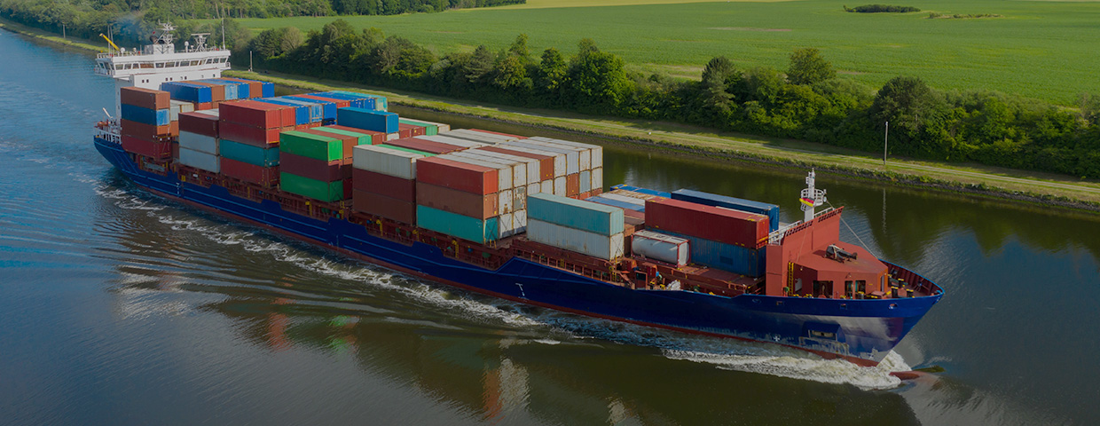 Container Ship On The Kiel Canal And Windmill On The Background