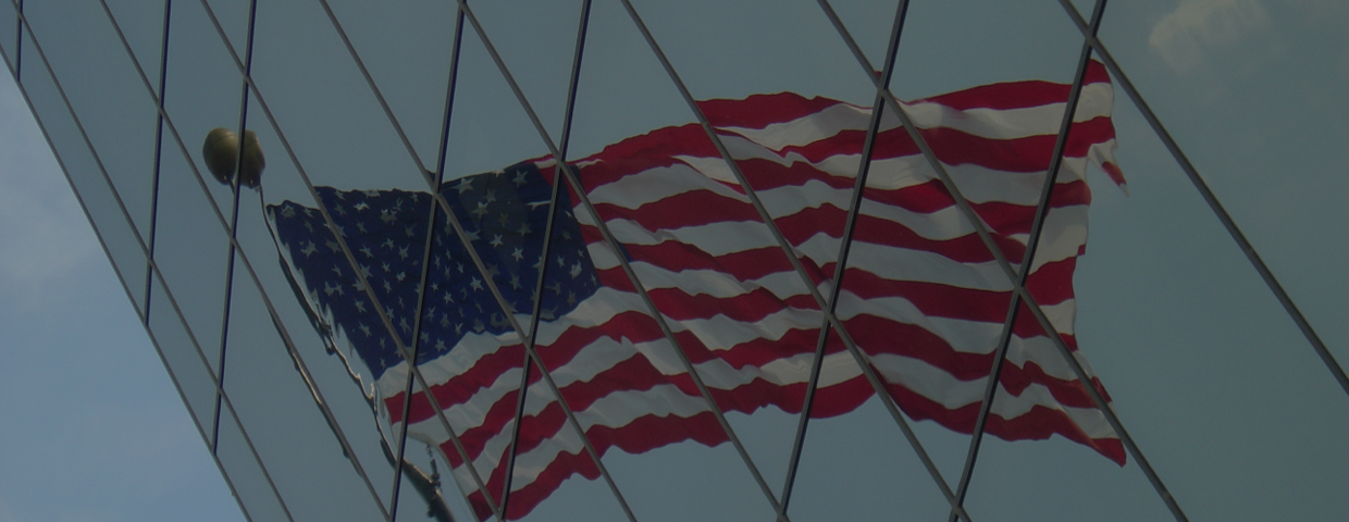 The American flag reflected on a skyscraper