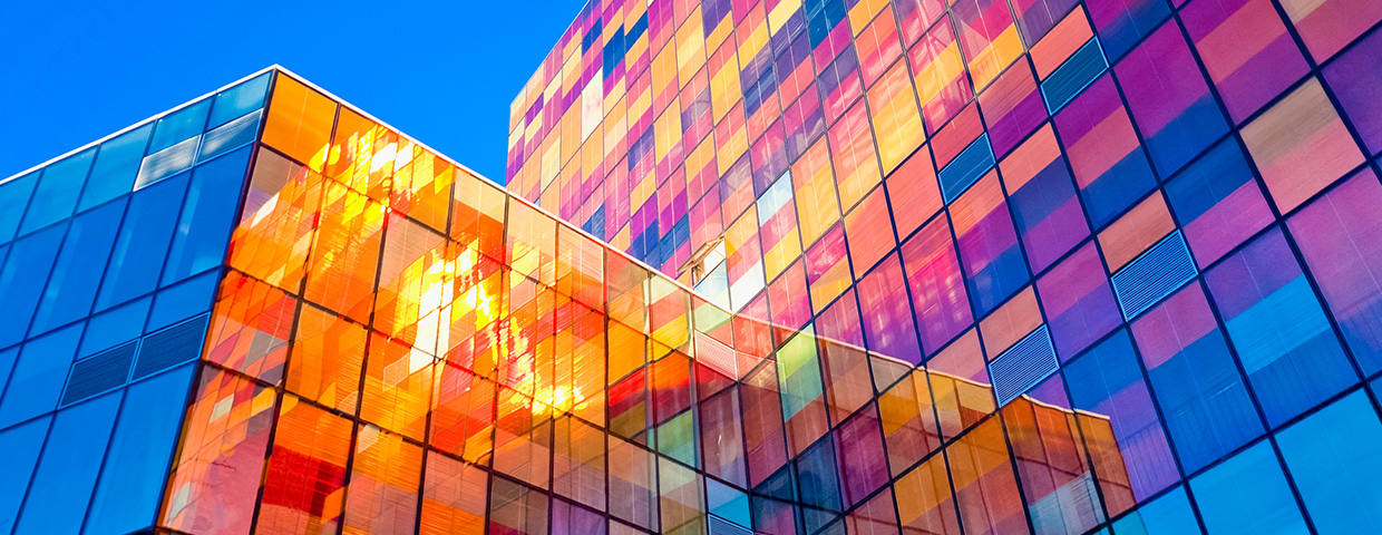 Two glass skyscrapers mirorring a myriad of colours