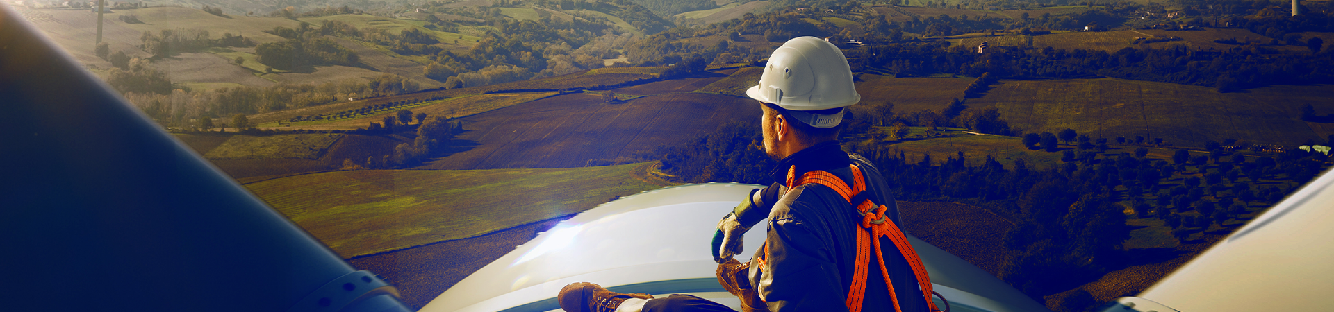Windpower technician sitting atop a wind power generator