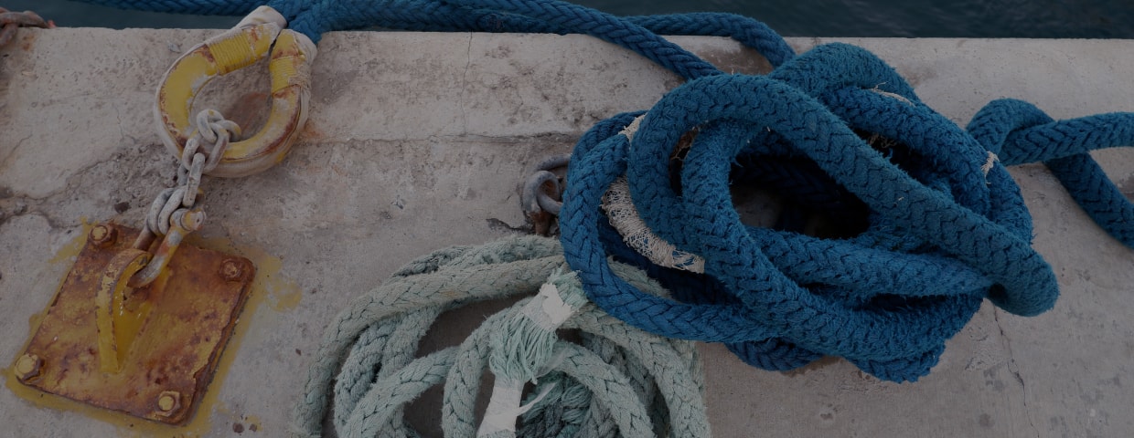 Close Up Image Of Blue Ropes Lying On The Concrete Deck Of Pier At Sea Coast