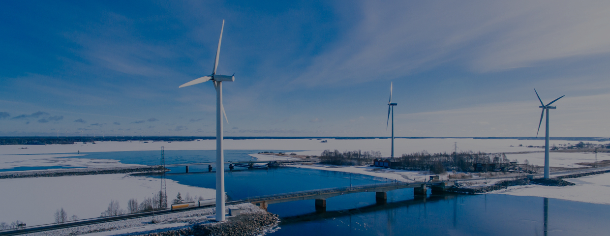 Aerial view of windmills with blue frozen river in snow winter Finland