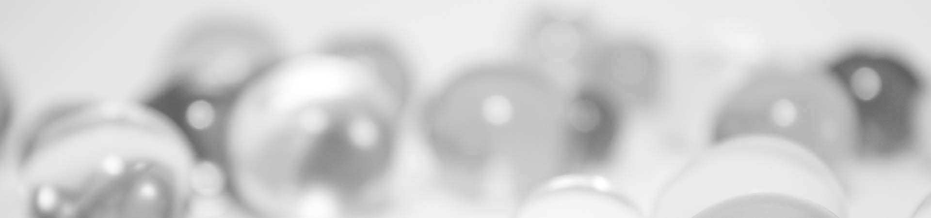 Clear glass marbles on a white surface bathed in light