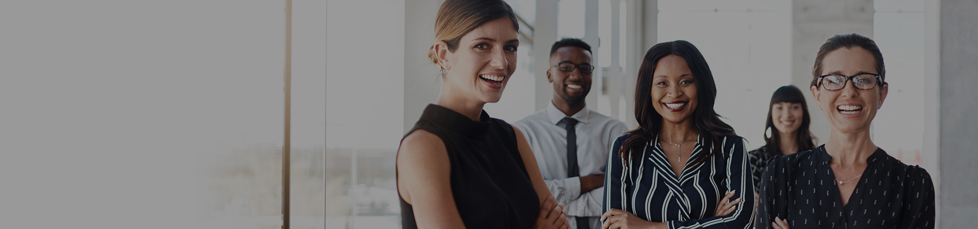 Shot of three businesswomen standing with colleagues in an office