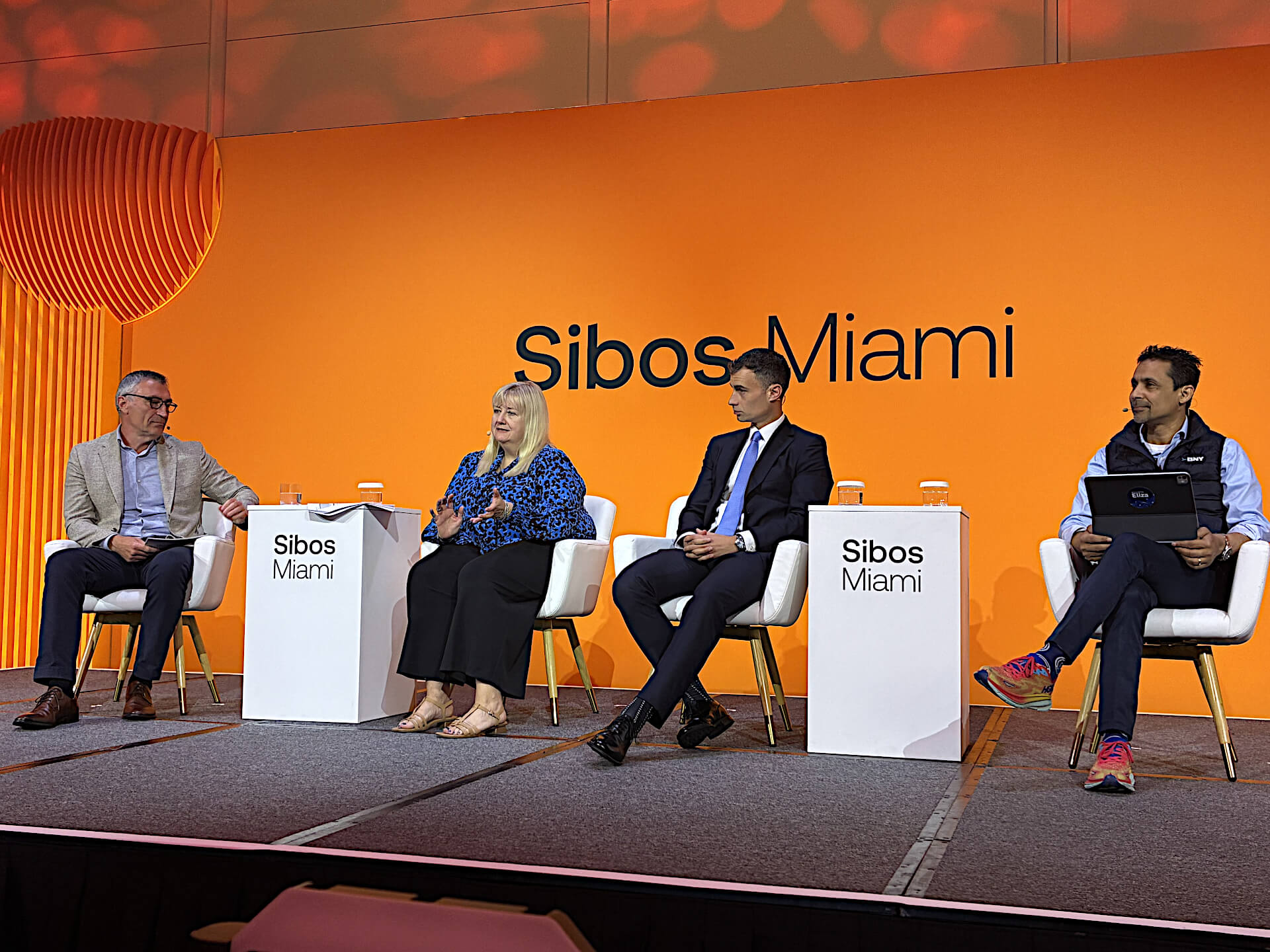 Four panelists engage in a discussion on stage at the Sibos Miami conference
